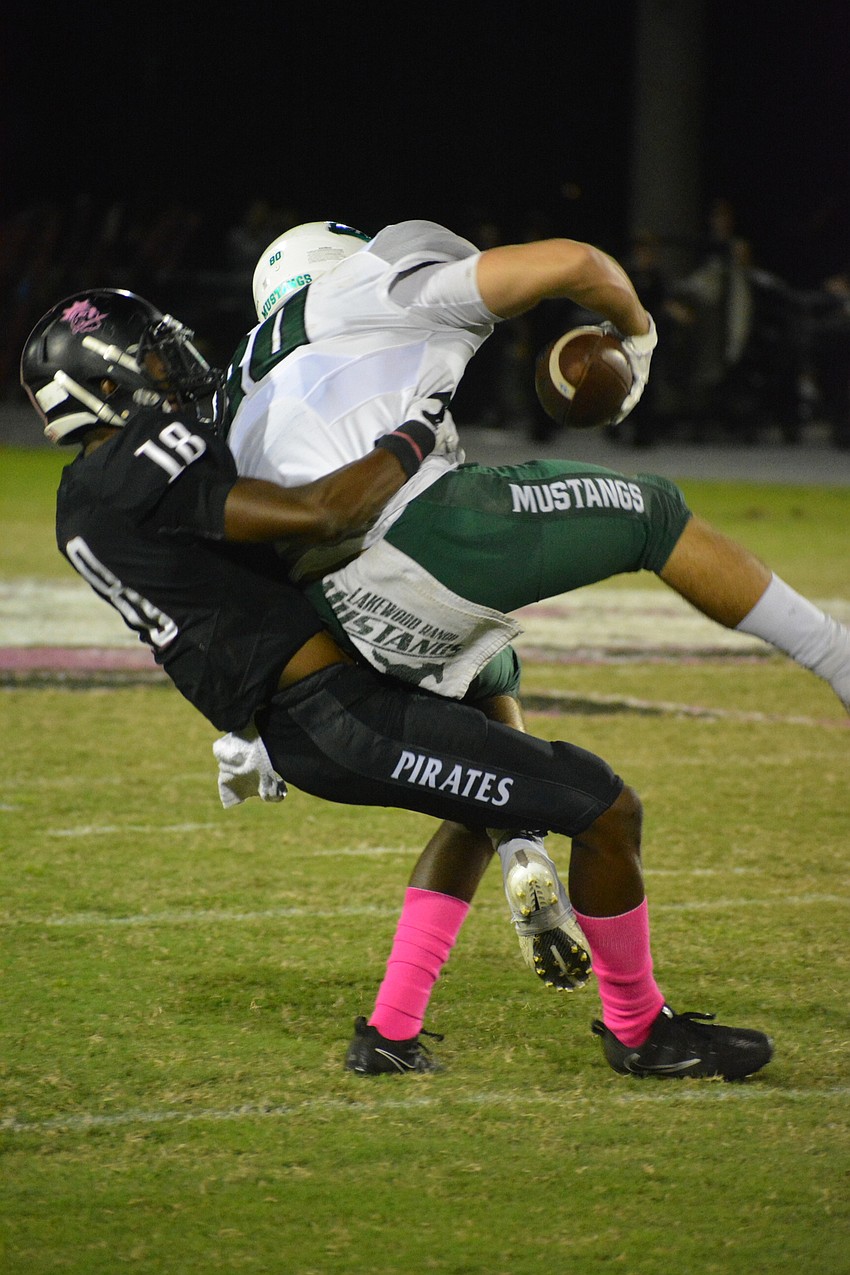 Pirates defensive back Jahvaron Burks suplexes Mustangs tight end Mickey Koczersut to the ground.