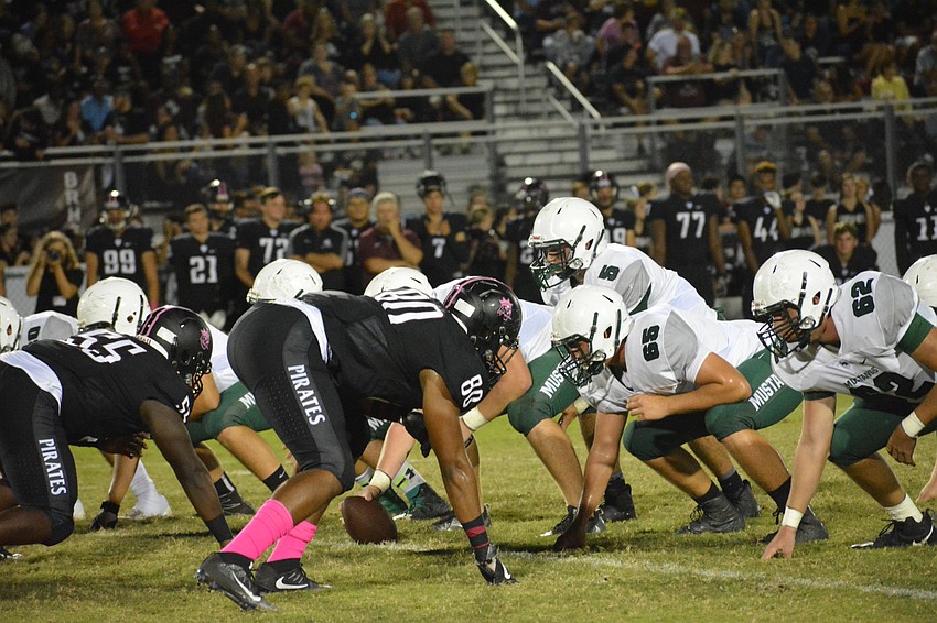 Mustangs quarterback Justin Curtis takes a snap from under center and surveys the Pirates defense.