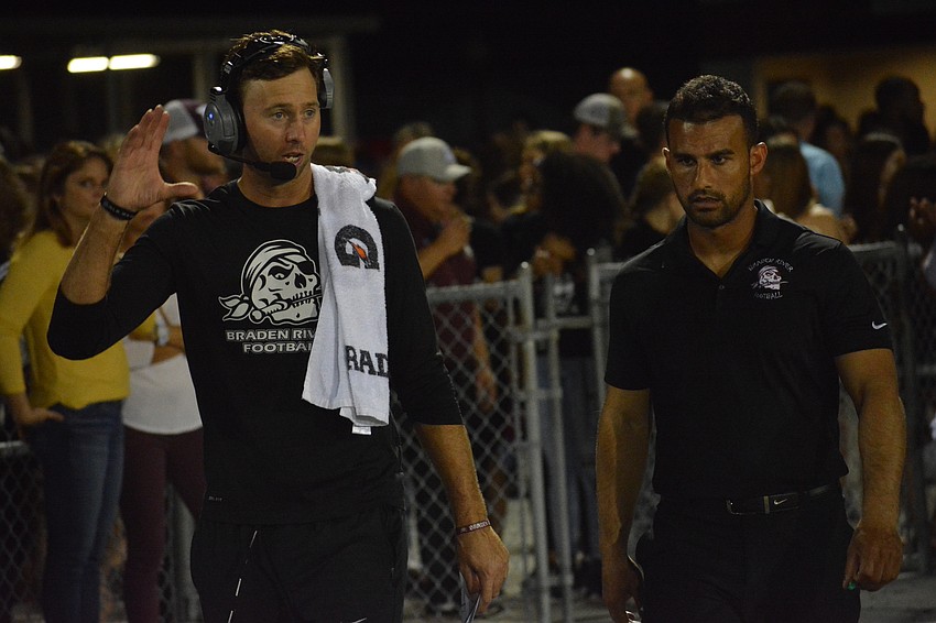Pirates offensive coordinator Eric Sanders and head coach Curt Bradley talk while coming out of the locker room for the second half.