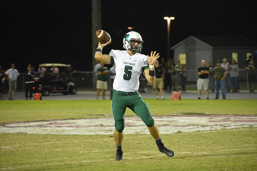 Mustangs quarterback Justin Curtis readies to launch a pass downfield.