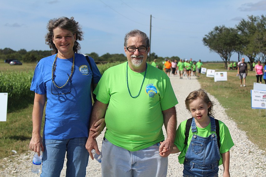 East County's Terri, Joe and Danielle Pelish lock hands as they embark on the Buddy Walk, raising awareness for Down syndrome.