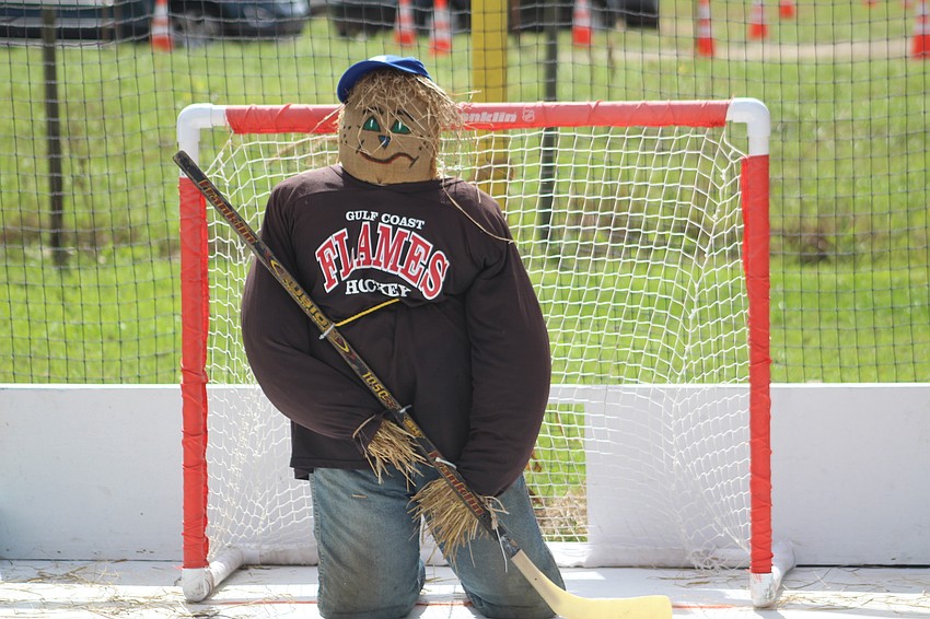 A scarecrow does his best to block hockey pucks during the Hunsader Farms Pumpkin Festival.