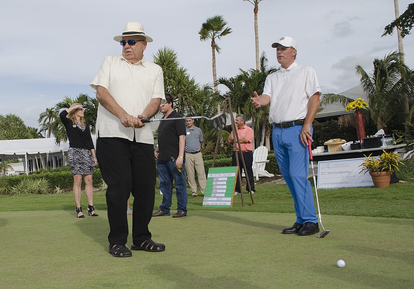 Former Public Works Director Juan Florensa (left) takes a practice shot with advice from Resort at Longboat Key Club Director of Golf Terry Ohara.