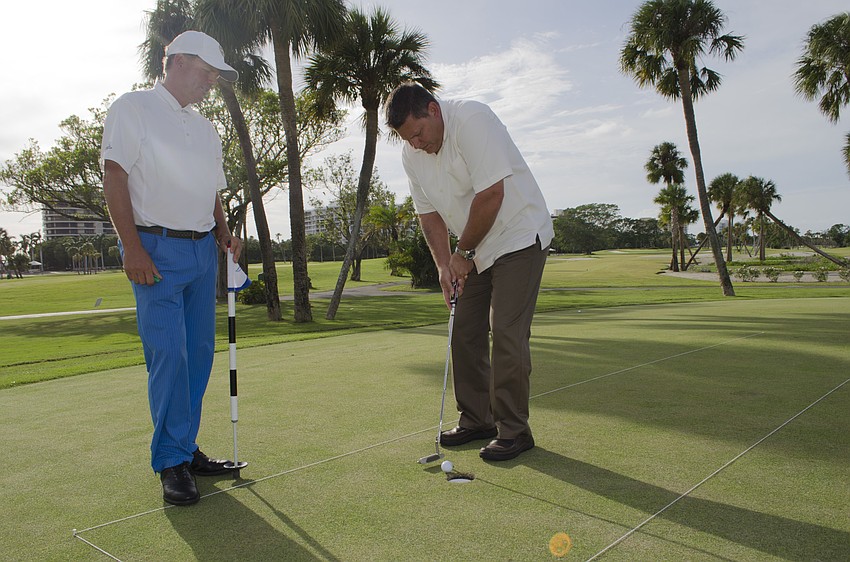 Deputy Police Chief  Frank Rubino (right) raised $1,100 for Longboat Key's emergency services Saturday, sinking his first and last shots in two two strokes, the second in three.