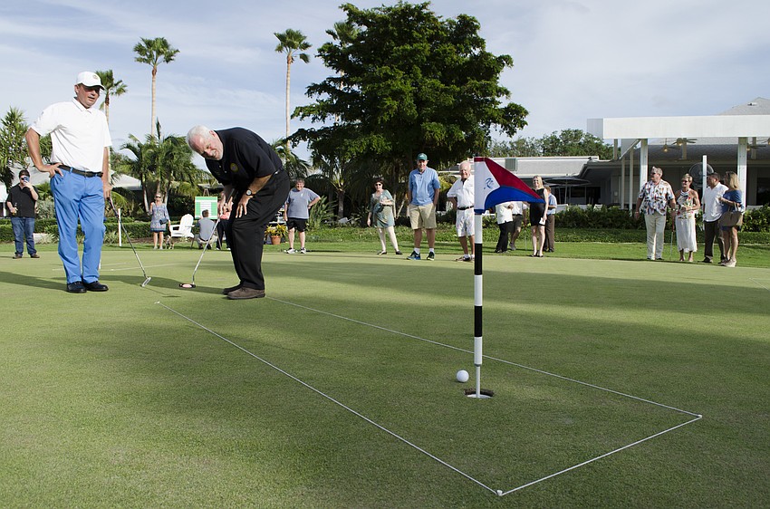Commissioner Irwin Pastor (right) raised $1,000 for the town's emergency services, sinking his first putt in two strokes and his second two in three.