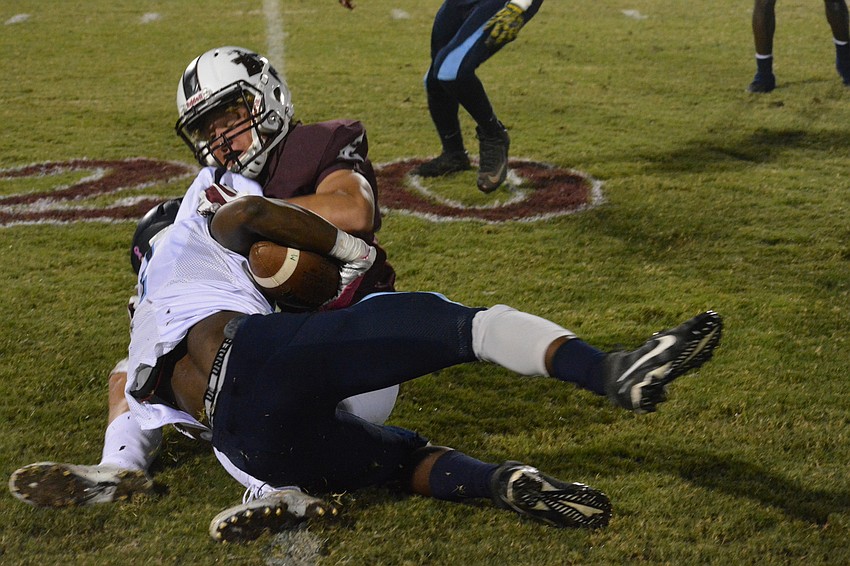 Braden River junior Jack Milner wrangles a North Port player to the ground.