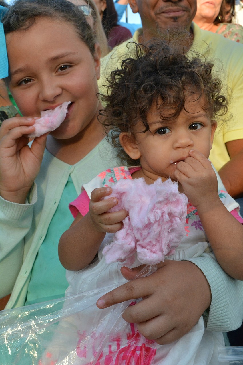 Maria and Fela Lodrini feast on cotton candy as they watch their brother, Marquise Lodrini, portray the role of Yost.