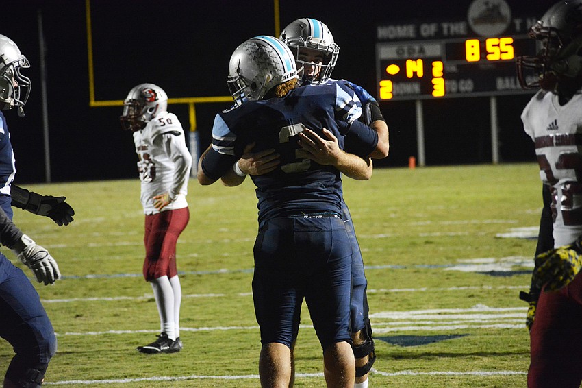 ODA running back Dakota Dickerson hugs quarterback Gus Mahler after punching in a goal line touchdown run.