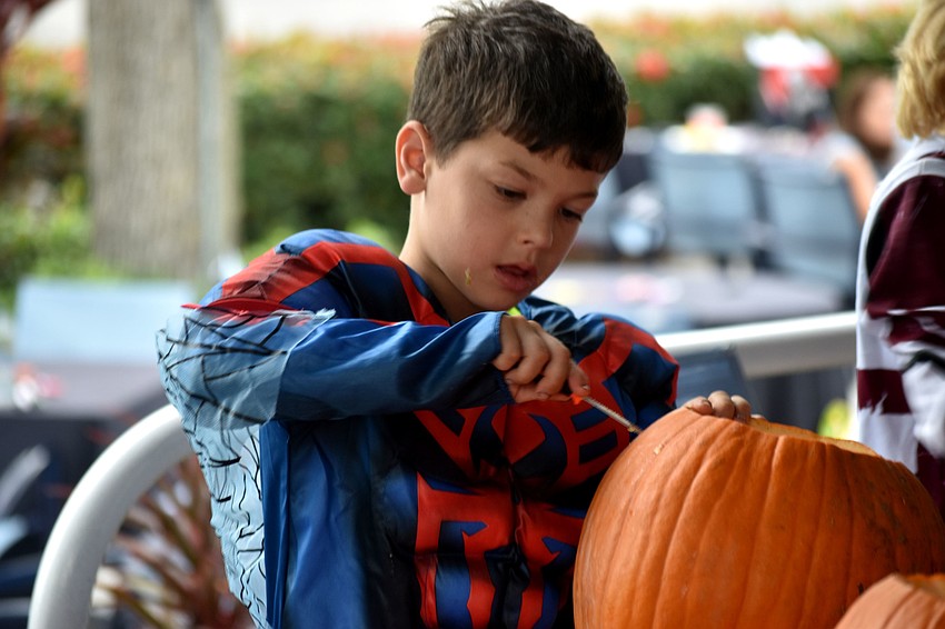 Cole Kaufman begins carving his pumpkin.