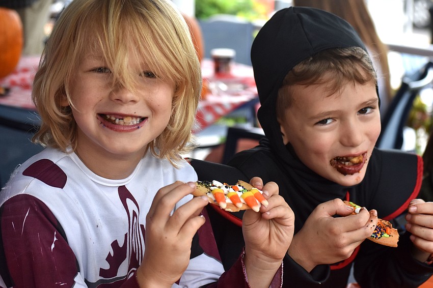 Jackson Brester and Leo Martin munch on their Halloween cookies.
