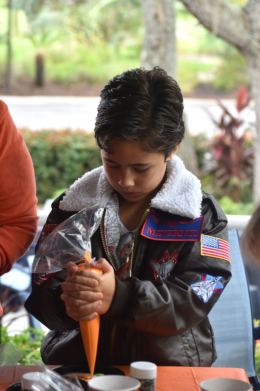 Charlie Rasool decorates a Halloween cookie.