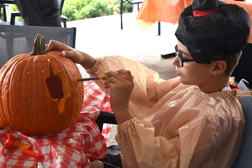 Robert Martin carefully carves his pumpkin.
