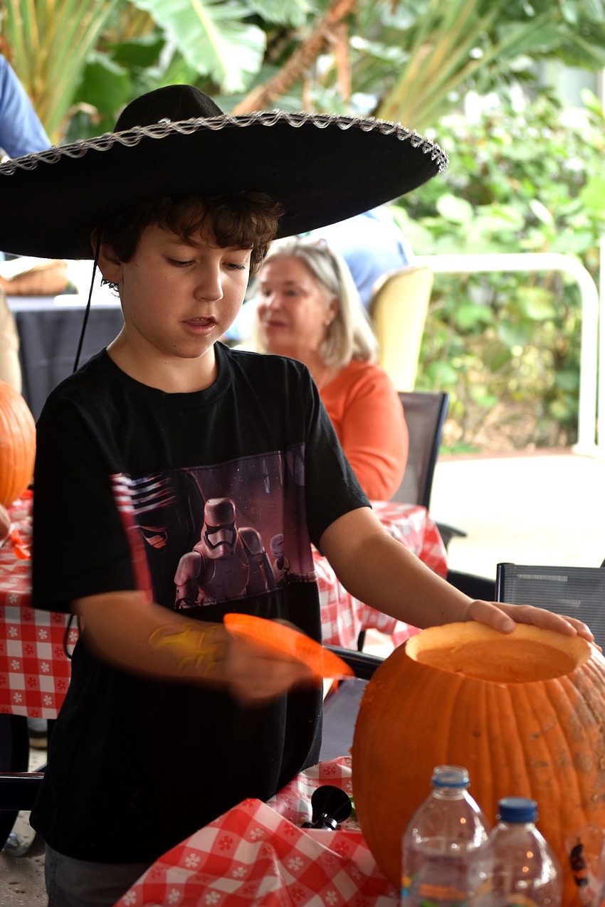 Adam Bomberger carves a pumpkin.