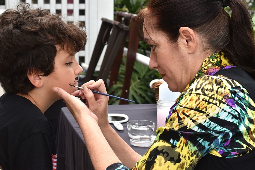 Adam Bomberger gets his face painted by Raquel Hemmer of Goodly Entertainment.