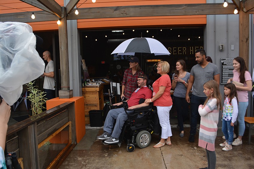 Shaina held an umbrella over Kevin's head as she started to wonder what was up.