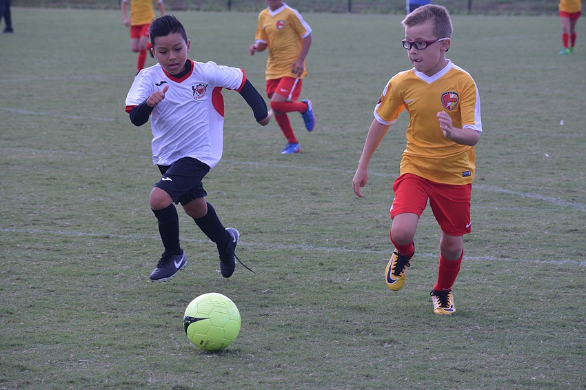 Lakewood Ranch U9 forward Jace Muye sprints to beat a defender to the ball and put a shot on net.