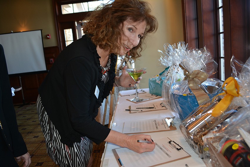 Humane Society Secretary Linda Dirk bids on a silent auction item after the golfers finish their rounds.
