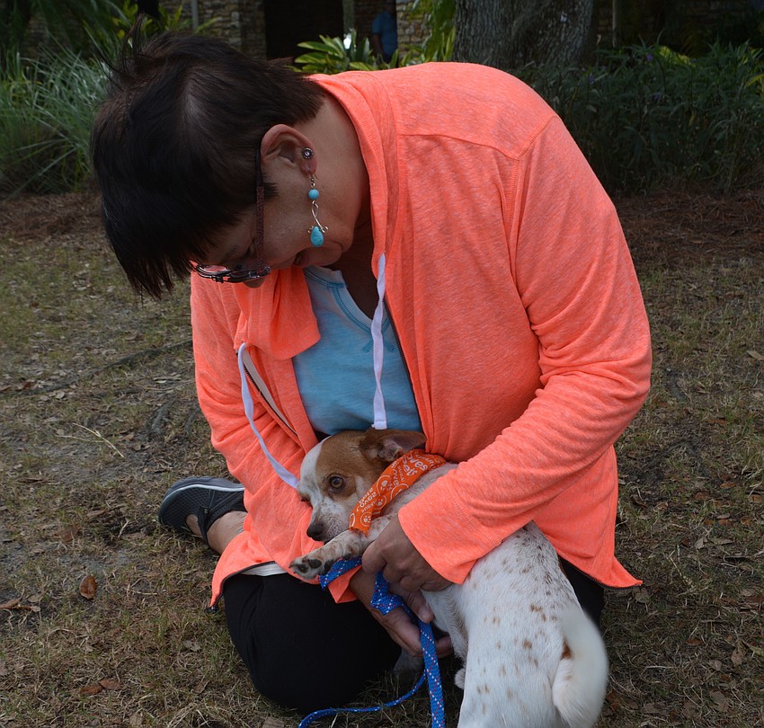 Humane Society volunteer Susan Groves keeps Conley, a 14-month old mix, busy during Putts Fore Mutts.