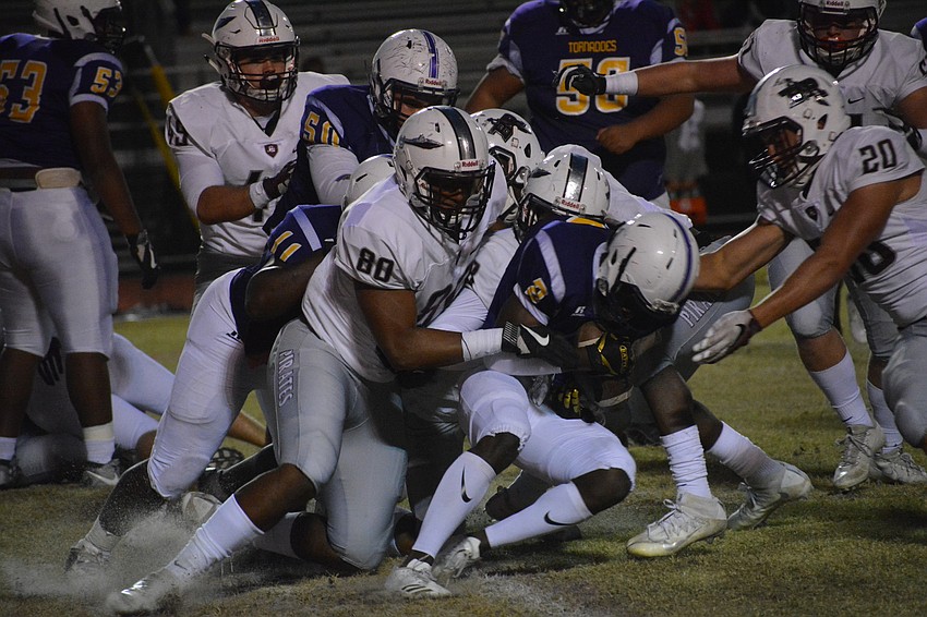 Braden River junior and University of Florida verbal commit Taylor Upshaw (80) leads a gang tackle of a Booker running back.