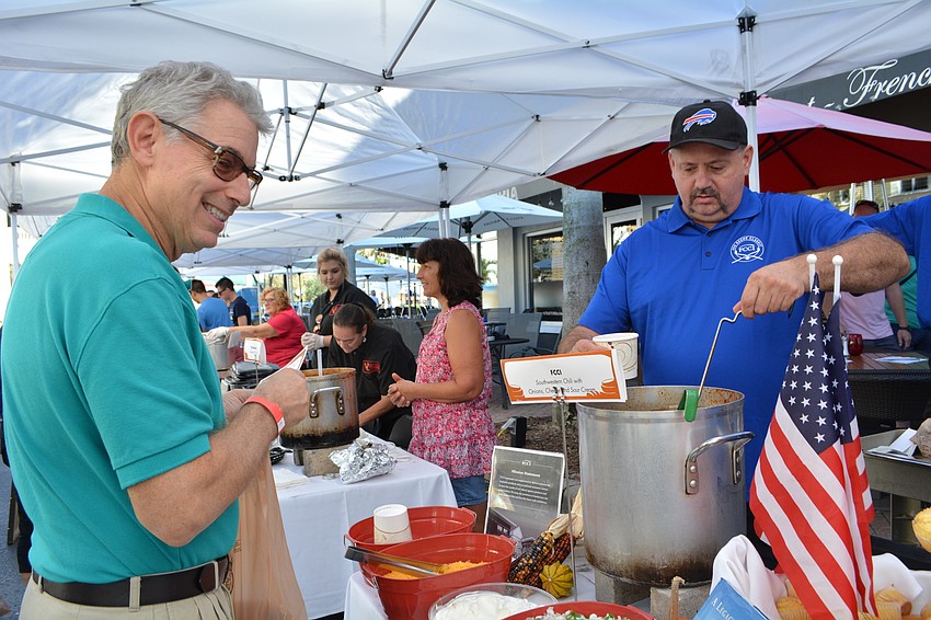 Anna Maria Island's Bruce Meyer, who works at  the Lakewood Ranch office of United Way Suncoast, gets bowl of chili from Scott Langdon, of FCCI. 