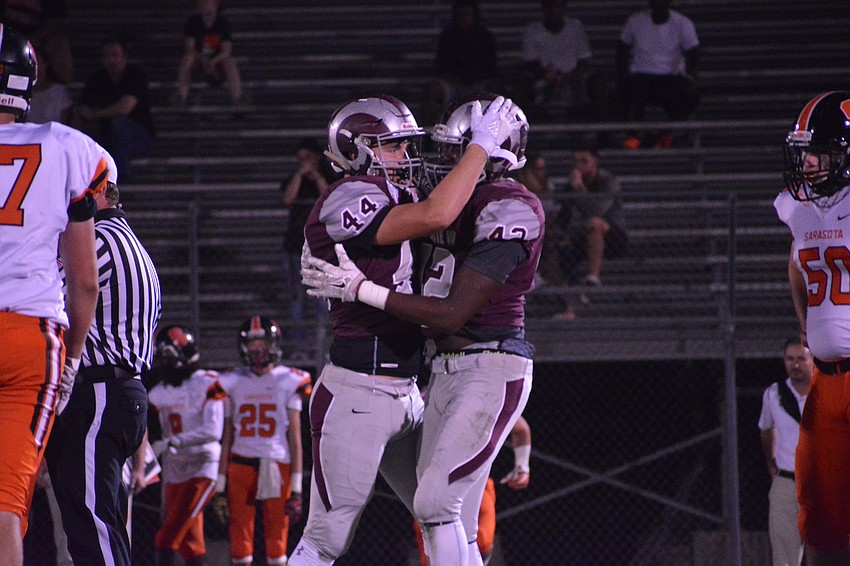 Riverview's Nick Nelson and Jayden Cray hug after a third-down tackle to stop the Sailors' drive.