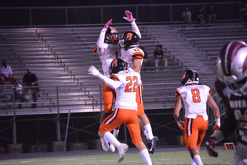 The Sailors' Charles Ward (1), Jason Scott (22) and Dante Maggio (11) celebrate a Rams turnover.