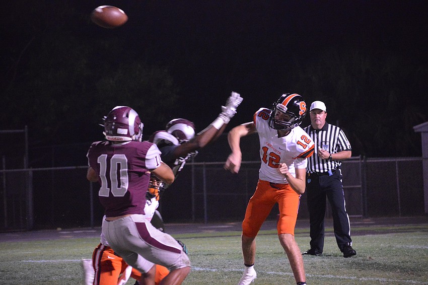 Sailors QB Vincent Parisi throws a pass in the face of pressure from Rams defenders.