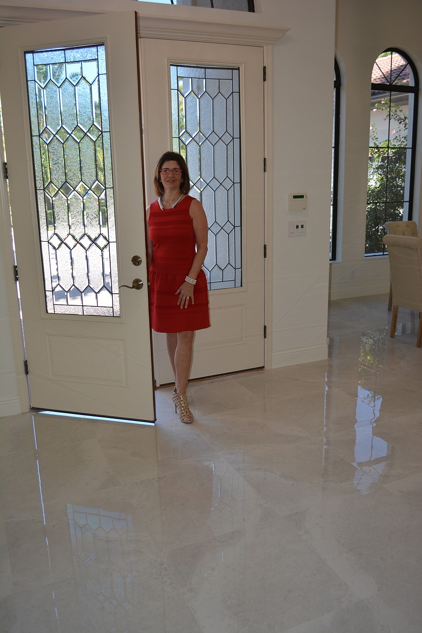 Donna Soda enters the home to show off the bright, light-colored flooring.
