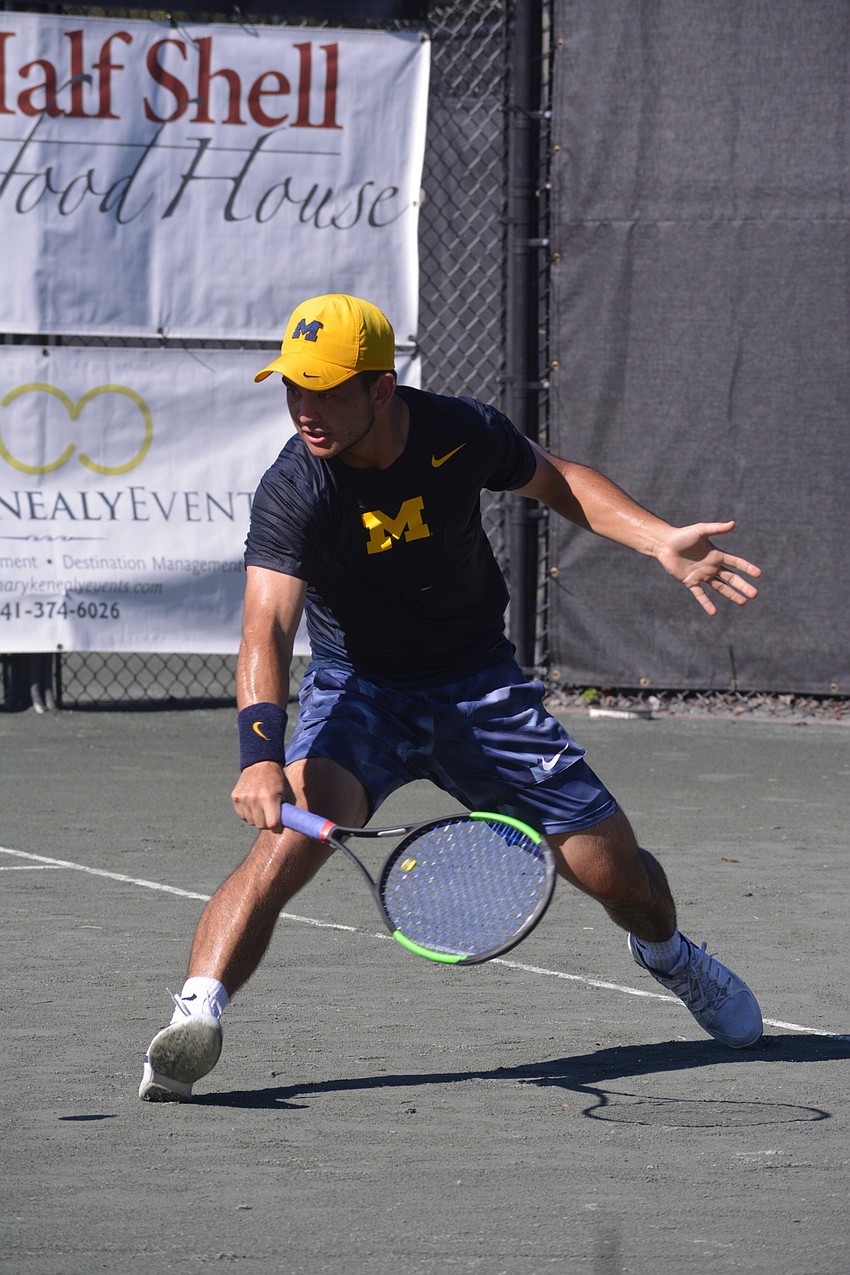 Michigan's Carter Linn bends to slice a shot back toward Florida's Andy Andrade and Jordan Belga.
