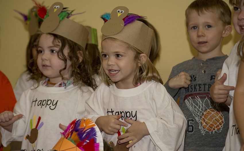 Emma Kayser smiles while performing for Temple Emanu-El preschool parents and staff during the school's Thanksgiving pageant.