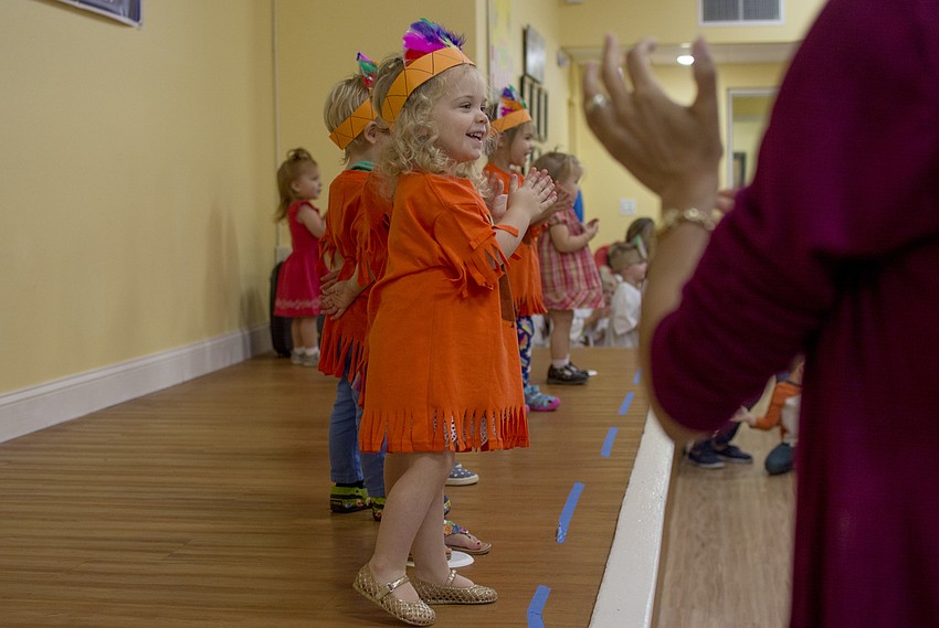 Cora Young applauds after performing for Temple Emanu-El preschool parents and staff during the school's Thanksgiving pageant.