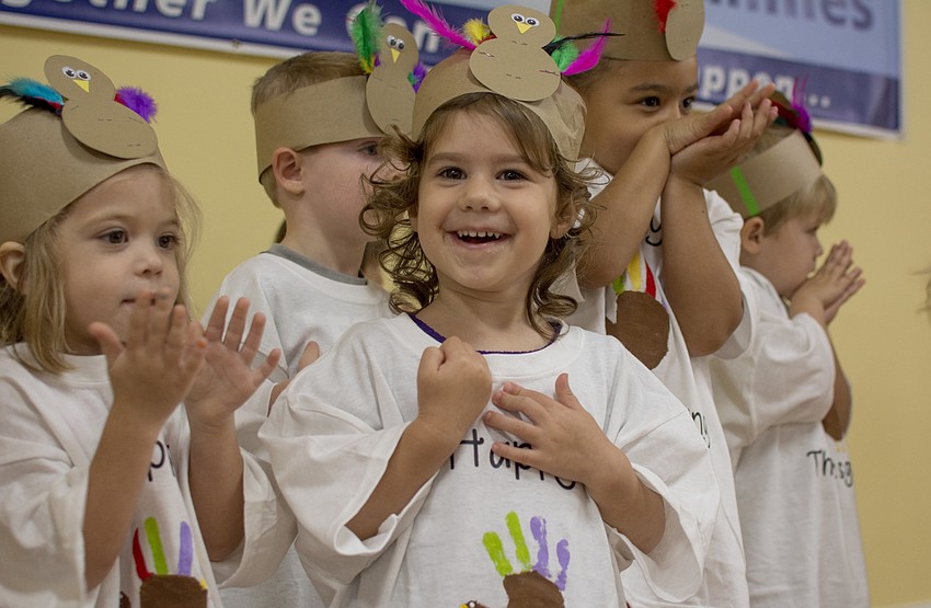Violet Kelly smiles while performing for Temple Emanu-El preschool parents and staff during the school's Thanksgiving pageant.