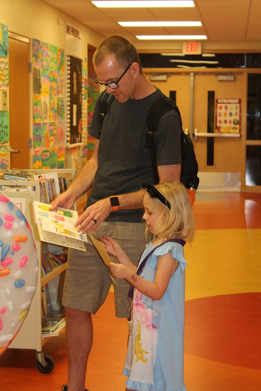 James Curran and his daughter, Ella, check out the huge selection of books.