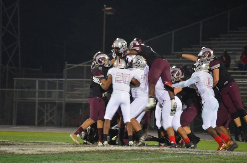 A grop of Riverview defenders combine for the tackle.