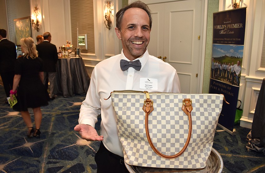 Soleman Sam Lowry models the Louis Vuitton purse he was assigned to sell.