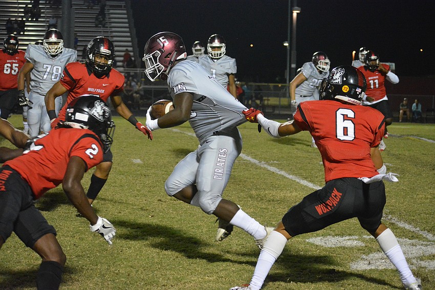 Junior Knowledge McDaniel rips through a defender's attempted jersey pull and gains more yardage.