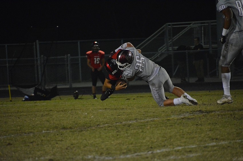 Chase Knopf drives the Wolfpack quarterback into the grass for a sack.