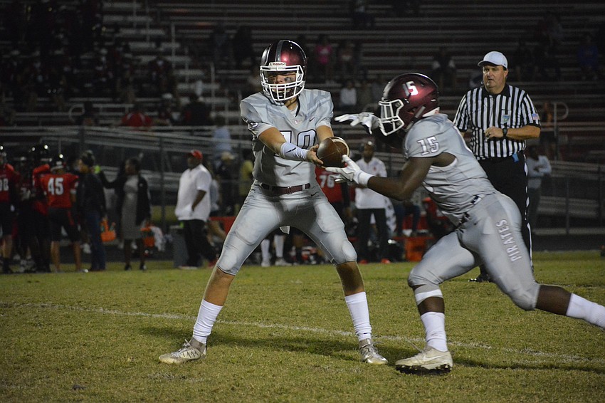 Bryan Gagg looks off the defense as he hands the ball to Knowledge McDaniel.