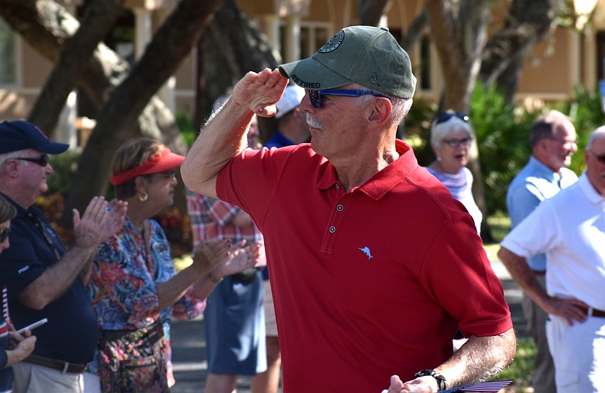 Bob Dods salutes Boy Scouts as he walks past them during the parade.