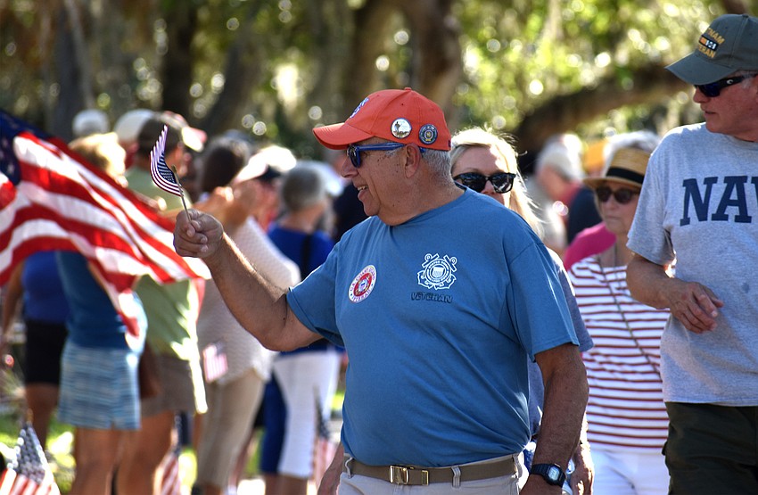 Veteran’s families wave to the crowd as they walk the parade route.