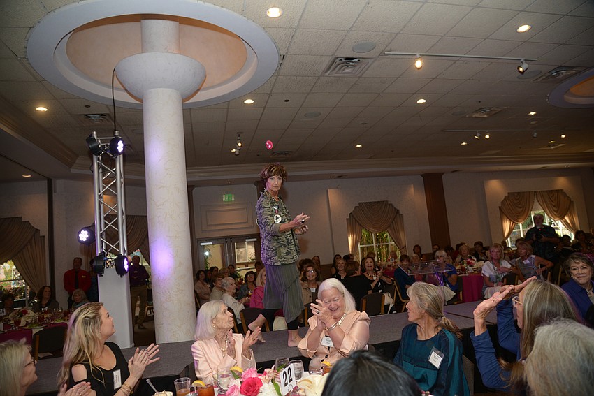 Guests clap for the fashion show models.