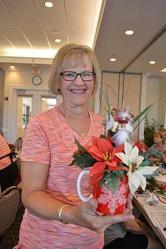 Cheryl Scheid, of the Lakewood Ranch Garden Club, decorates a special Christmas gift for seniors in the Meals on Wheels of Manatee program. Photo by Pam Eubanks.