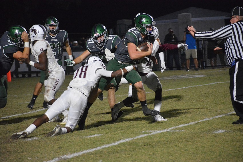 Pirates senior defensive back Jahvaron Burks wrangles Venice senior quarterback Bryce Carpenter for a sack.