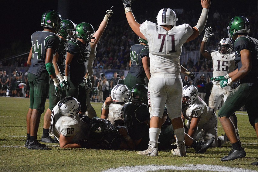 Brendan Bengtsson (71) and Knowledge McDaniel (15) signal touchdown after a Deshaun Fenwick goal line dive.