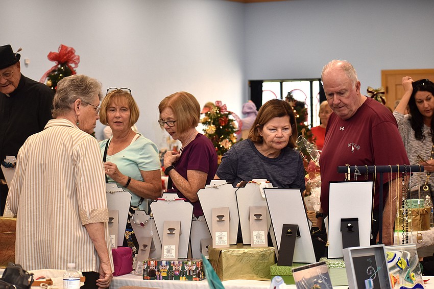 Bazaar shoppers check out the jewelry on sale.