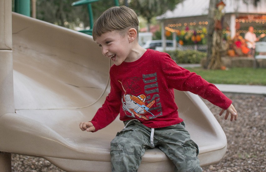 Finn Shkor plays on the playground in Laurel Park during the neighborhoods Tunes in the Park event.