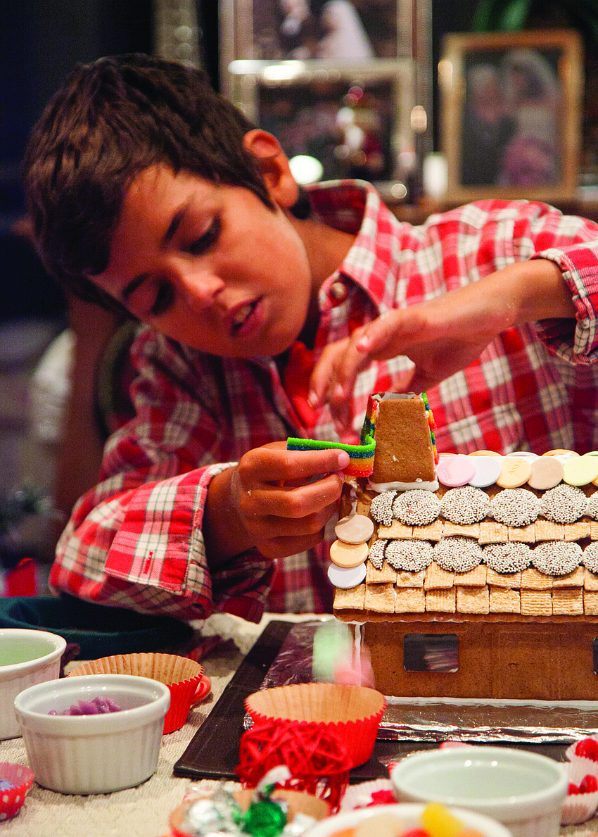 Julie Deffense's nephew Lawrence Deffense decorates a gingerbread house. Courtesy photo.