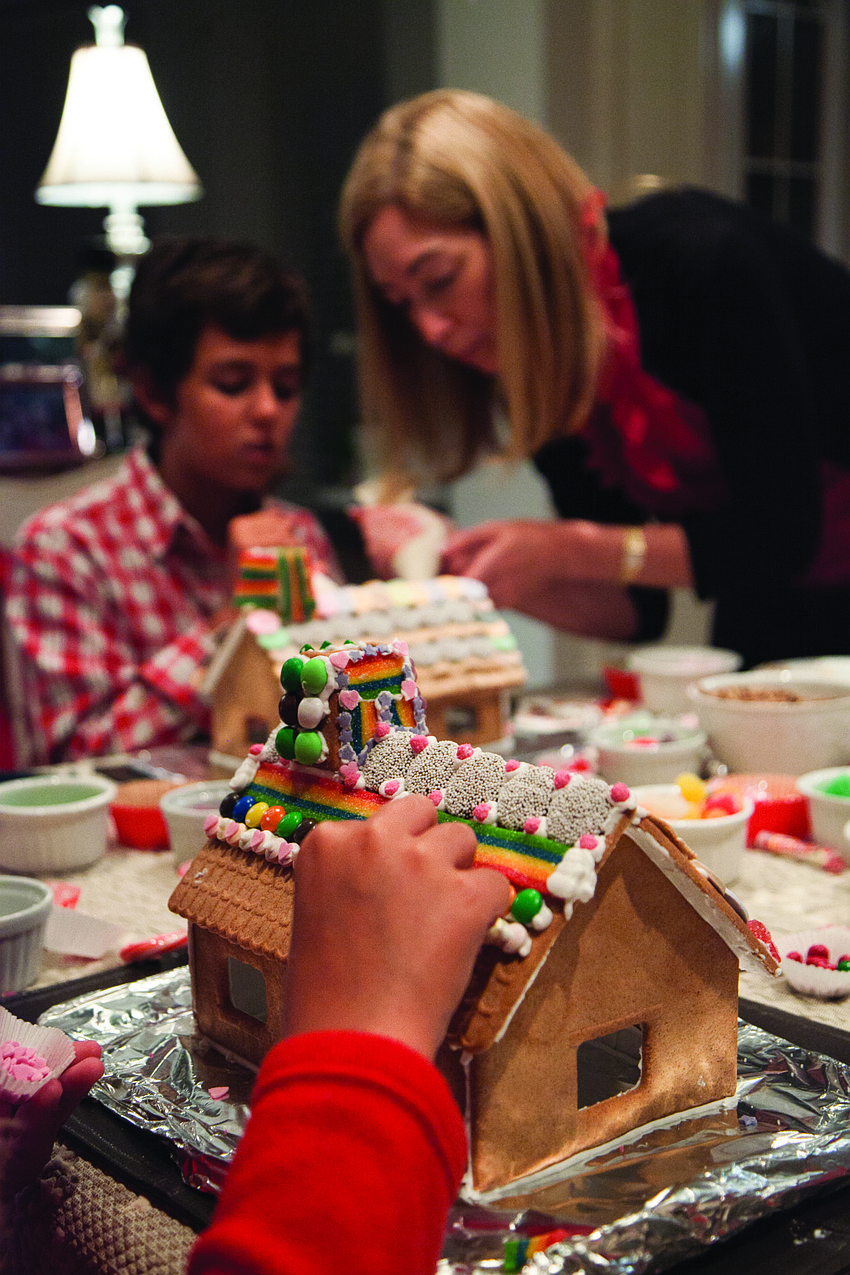 Julie Deffense helps her nephew Lawrence Deffense decorate a gingerbread house. Courtesy photo.