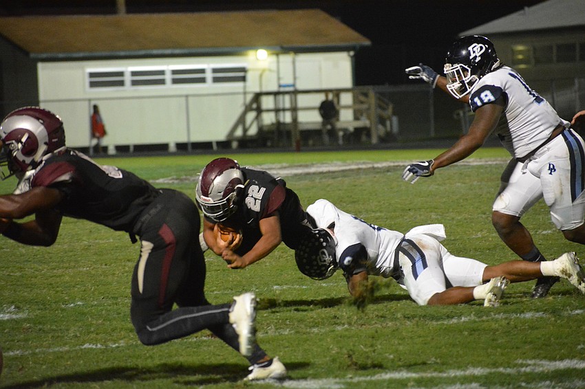 Junior running back Ali Boyce (22) gets dragged down by the ankles after a short gain.