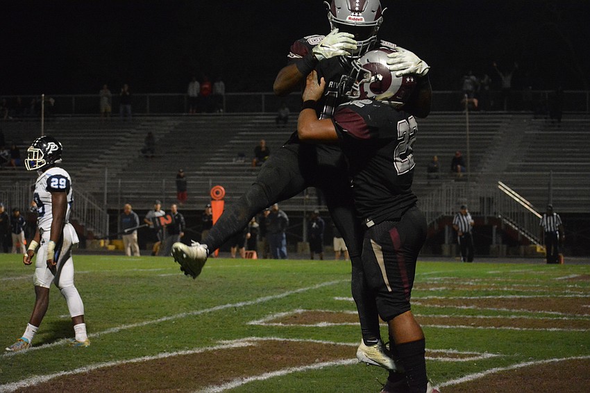 Stephon Turner (18) and Ali Boyce (22) celebrate following a Boyce touchdown run in the second half.